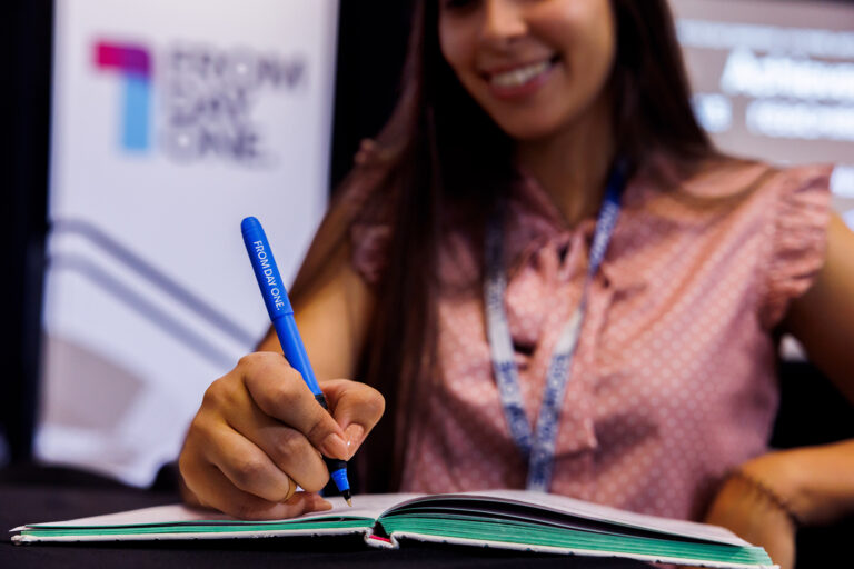 nyc-conference-photographer-attendee-smiling-taking-notes - Dro Photography & Video